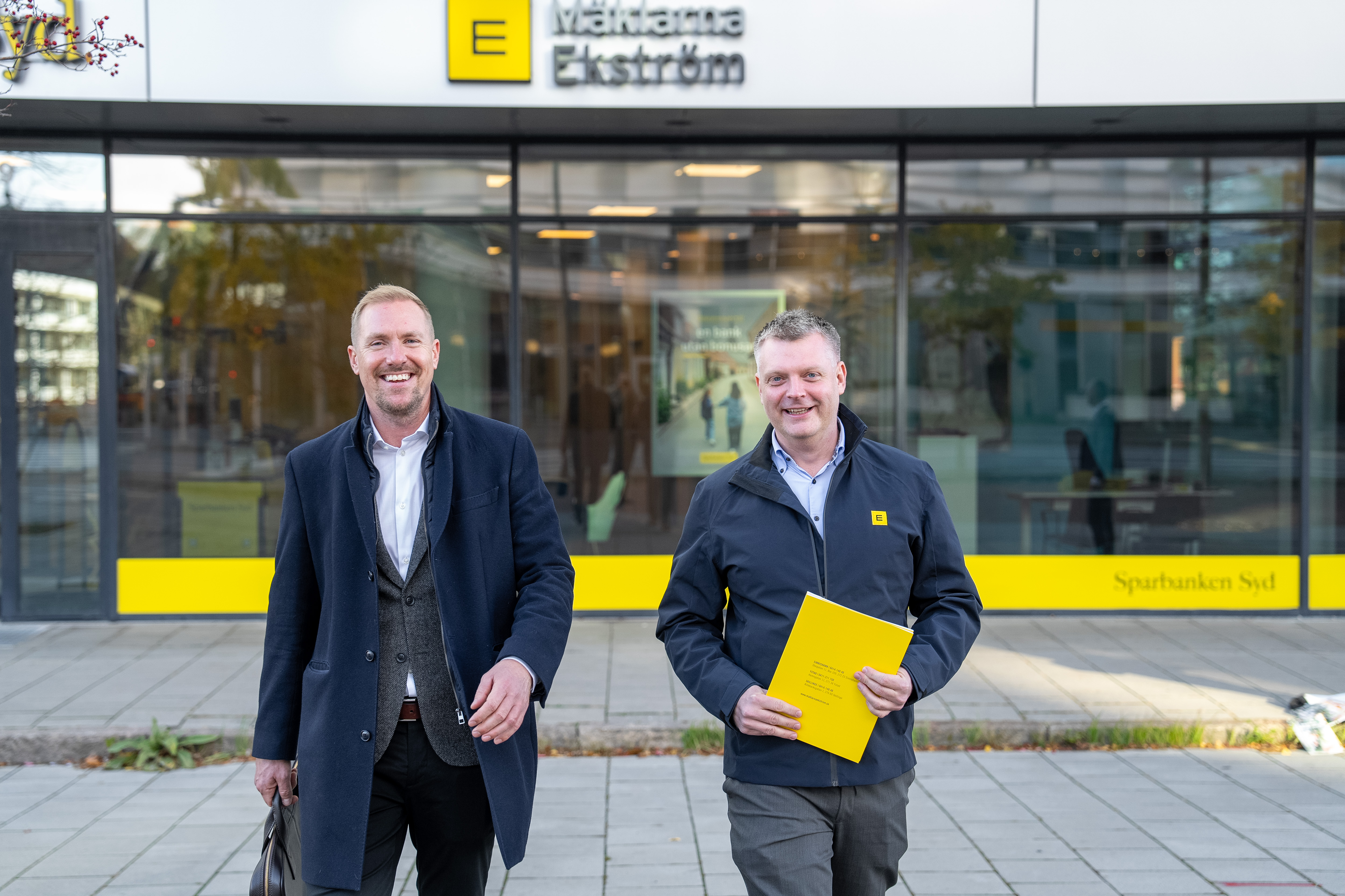 Fastighetsm&auml;klare Daniel Lundstam och Marcus Persson ler mot kameran utanf&ouml;r sitt kontor M&auml;klarna Ekstr&ouml;m i Malm&ouml;